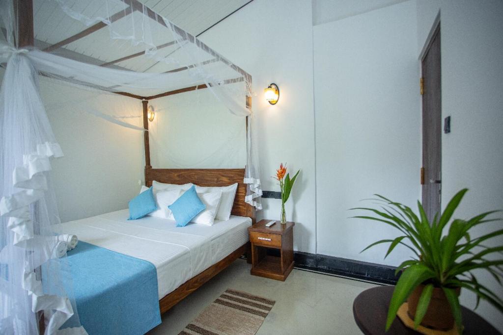 un dormitorio con una cama con dosel en Sleeperwood Villa, en Unawatuna