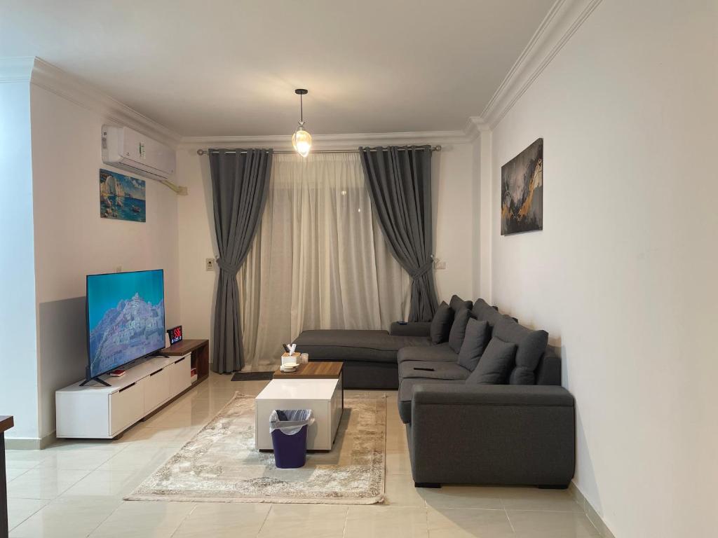 a living room with a couch and a tv at Madinaty golden stay in Madinaty
