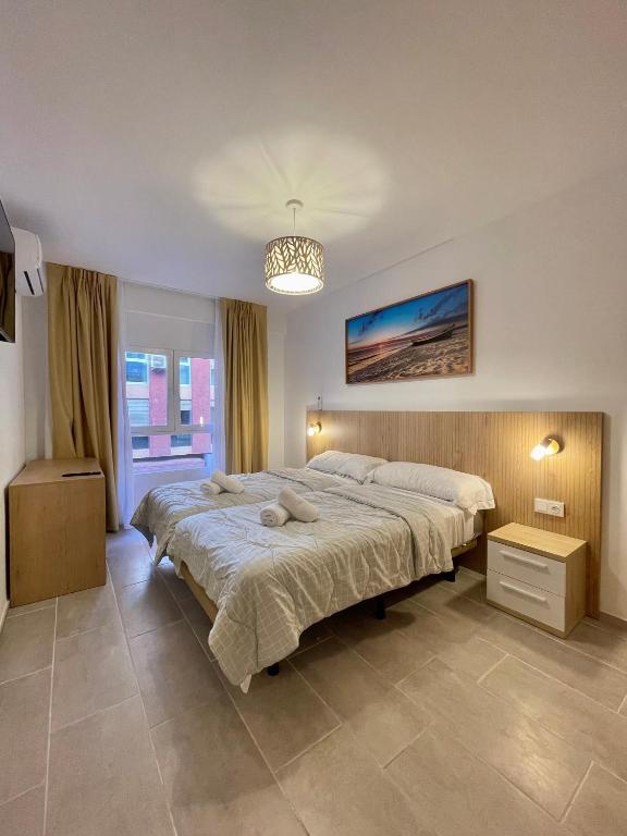 a bedroom with a large bed and a chandelier at Barocco Rooms Hostel in Alicante