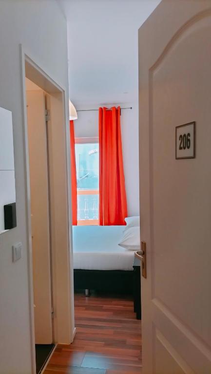a room with a window with a red curtain at Hotel Miranda & Miranda in Ponta do Sol