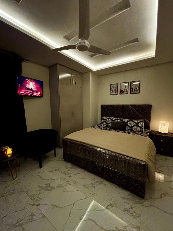 a bedroom with a bed and a flat screen tv at The little nest in Islamabad
