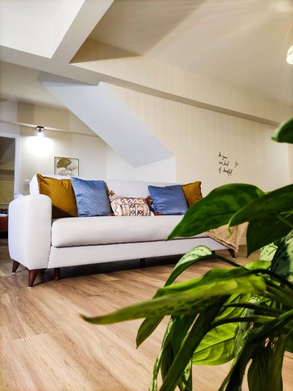 a living room with a white couch with blue pillows at Vitoria's Vale in Funchal