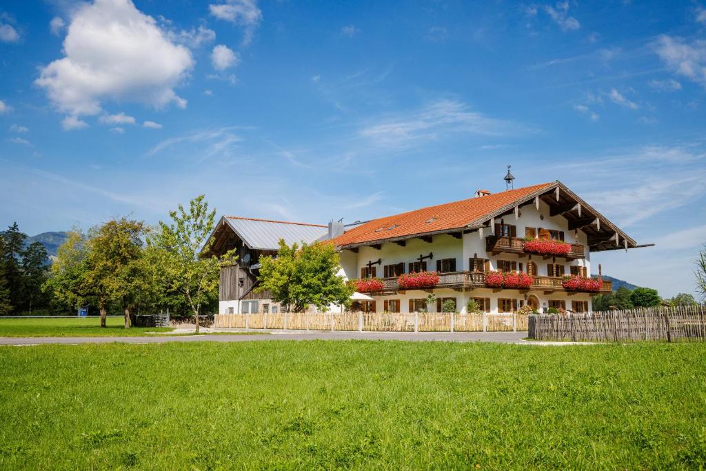 a house with a red roof on a green field at Knoglerhof inkl. Chiemgaukarte in Ruhpolding