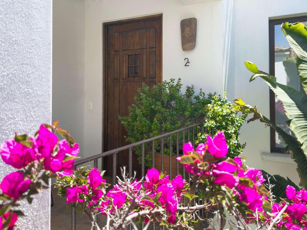 a front door of a house with pink flowers at Casapueblo Rent Cachagua CP 02 in Cachagua