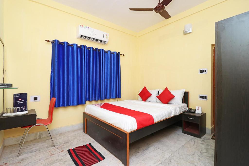 OYO Hotel O Maa Tara Guest House في Jādabpur: غرفة نوم بسرير وستارة زرقاء