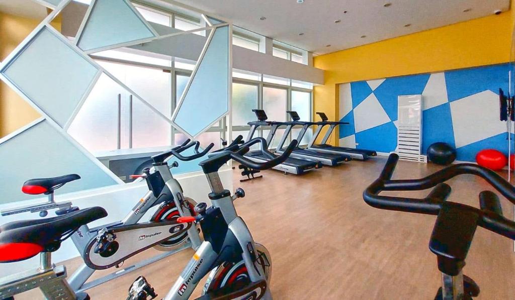 Un gimnasio con varias bicicletas estáticas en una habitación. en J&A Cozy Calm Stay, en Biñan