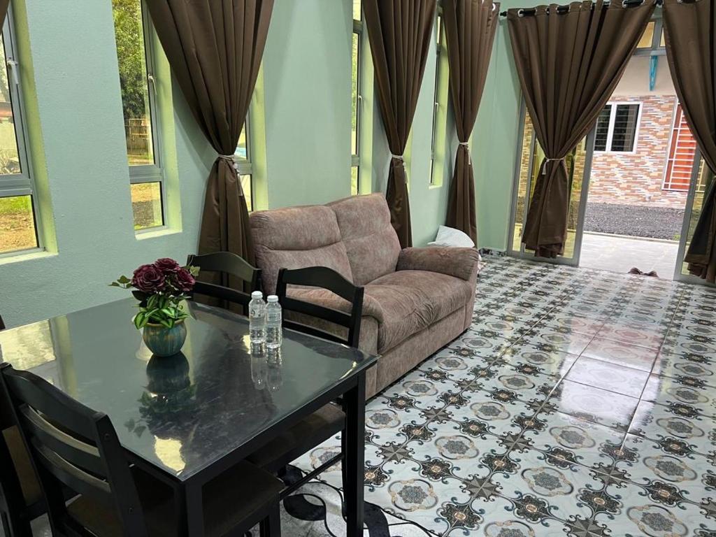a living room with a couch and a table at Inara Homestay in Kepala Batas