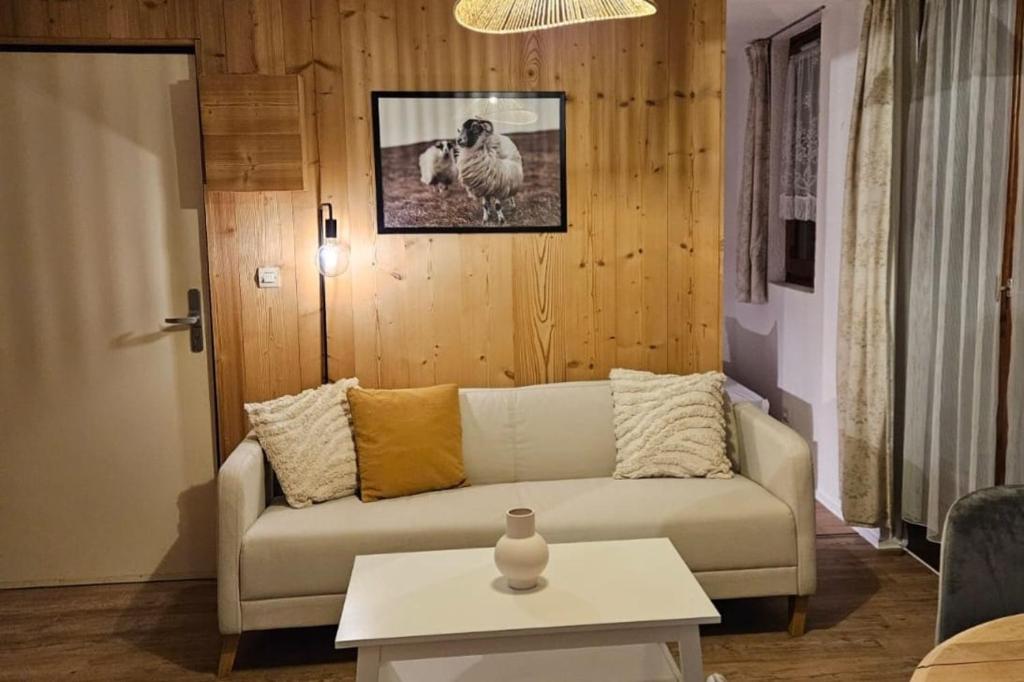 una sala de estar con un sofá y una mesa en L'Epicéa - Logement Nature, en Mijoux