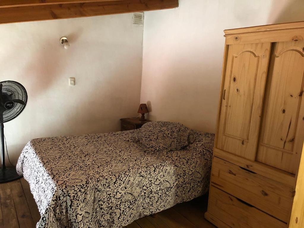 Un dormitorio con una cama y un armario de madera. en Piltri duplex, en El Bolsón