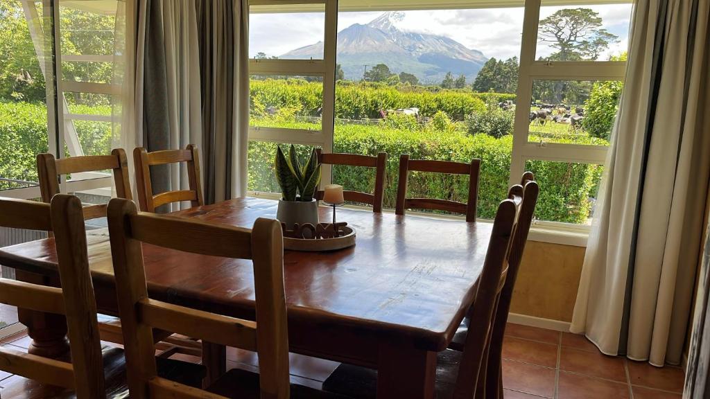 tavolo da pranzo con vista sulle montagne di Mount Taranaki Basecamp 4BR Farmhouse & Games Room 