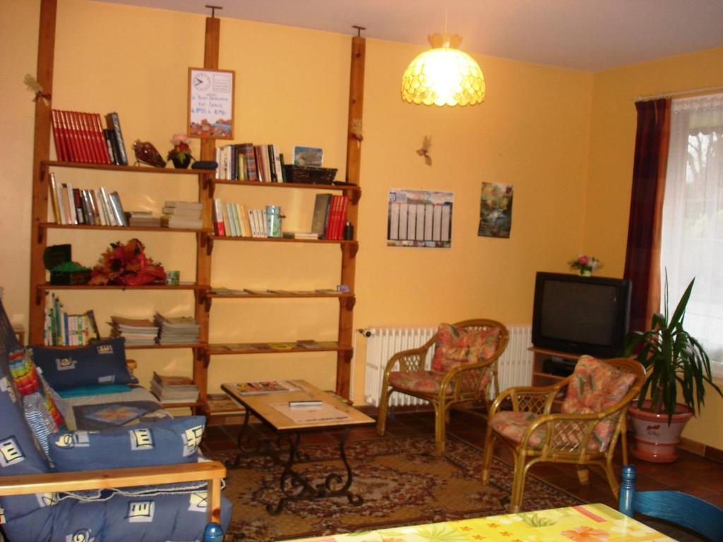 ein Wohnzimmer mit einem Tisch, Stühlen und einem TV in der Unterkunft Le Stang in Le Croisty