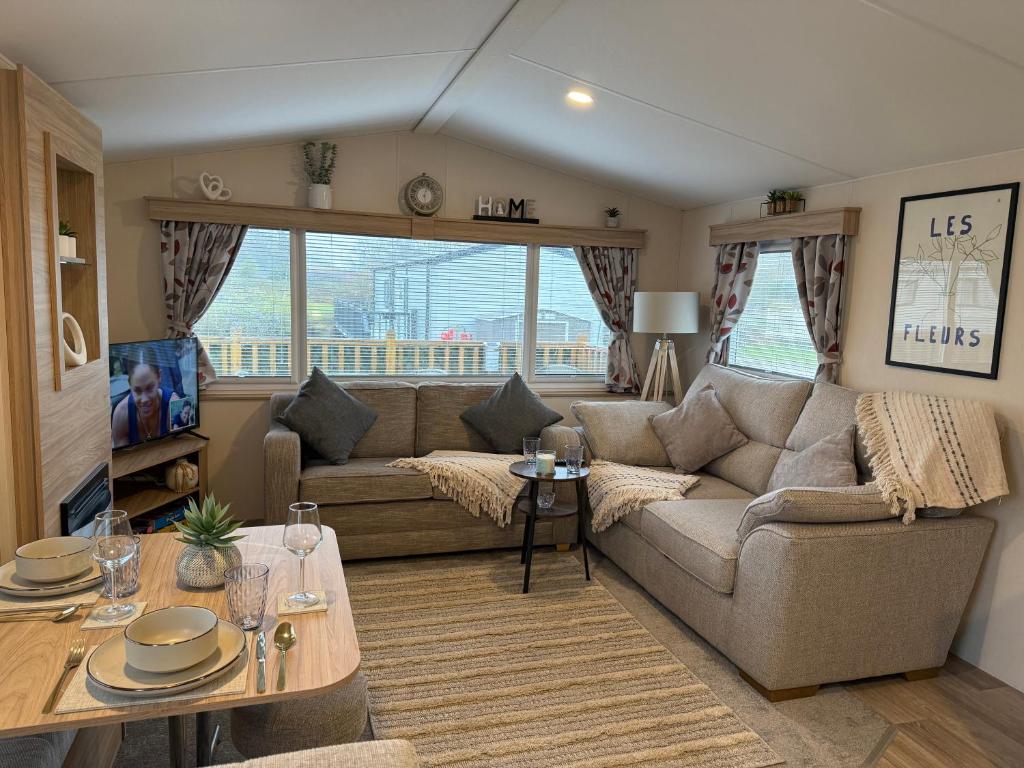 a living room with a couch and a table at Riverside Haven in Crowle