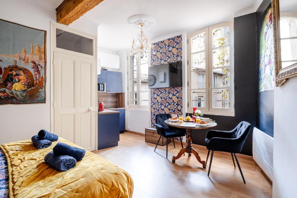 una camera da letto con un letto, un tavolo e delle sedie di Le Romantique - Place St Didier - Cœur de ville ad Avignone