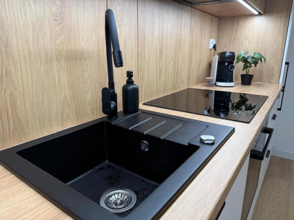 una cucina con lavandino nero di Old Town Bulwar Apartment a Elblag