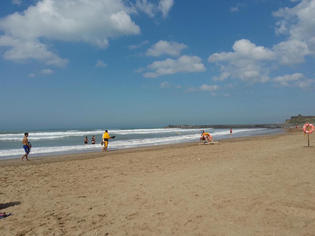 a group of people walking on the beach at AmoVertecasadeveraneo in Colonia Chapadmalal