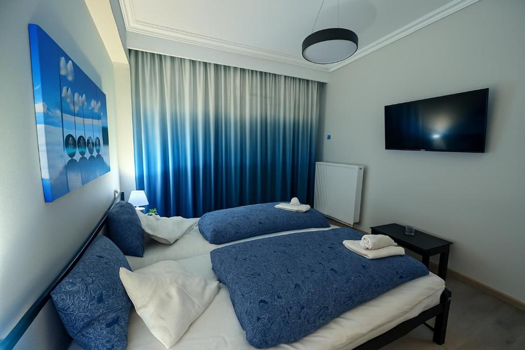 Dos camas en una habitación de hotel con almohadas azules. en Serres city center modern apartment (Monika), en Serres