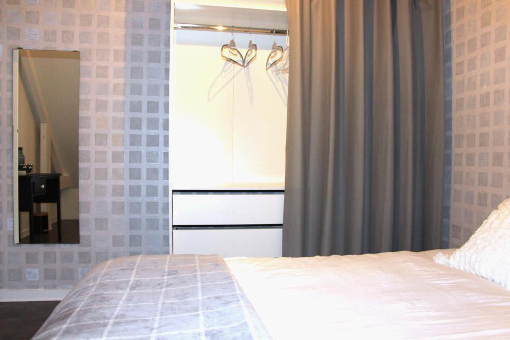 a bedroom with a bed and a dresser and a mirror at Chambre d'hôtes cosy à la campagne in Bourg-des-Comptes