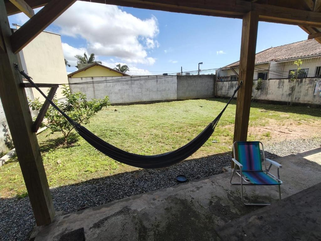 a hammock and a chair in a yard at Casa Praia in Piçarras