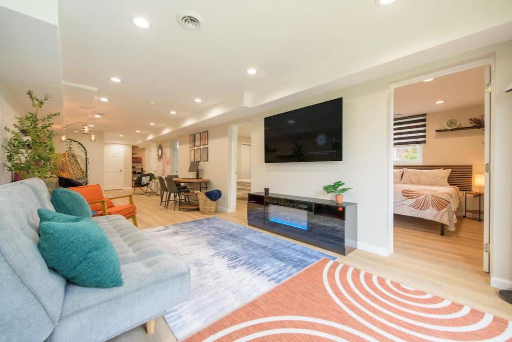 Una sala de estar con un sofá y un televisor en Entire Modern Cozy 2BR Apt mins SU LeMoyne DT, en East Syracuse