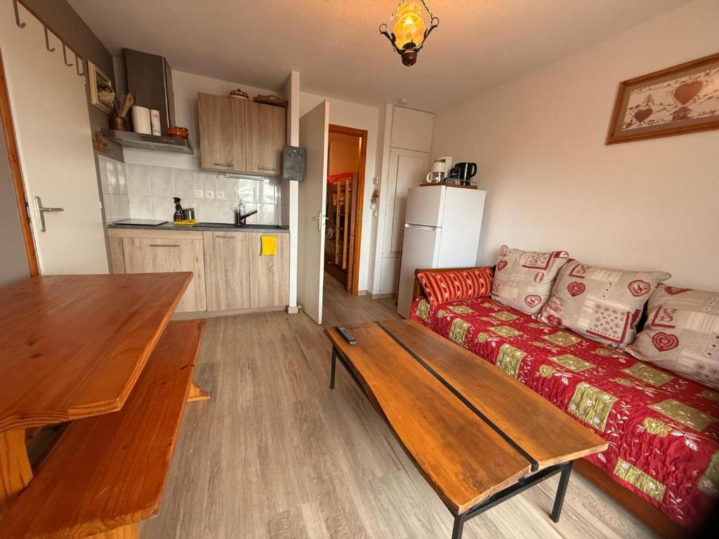 apptT2 station ski familiale في تولو: غرفة معيشة مع أريكة وطاولة خشبية