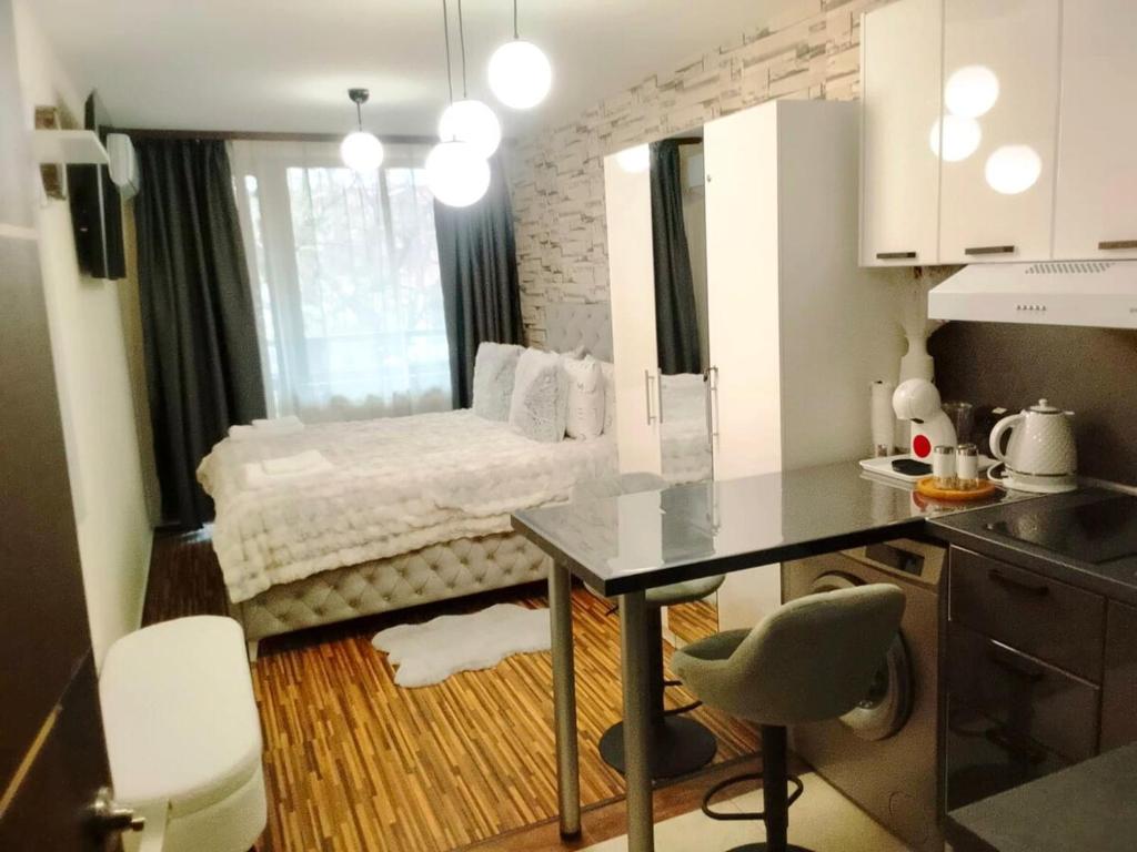 a small kitchen with a table and a bed in a room at Luxury studio Perun Lodge in Bansko