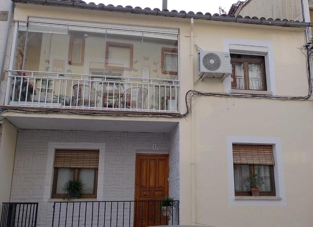 a white house with a balcony with chairs on it at Flor de Loto in Candeleda