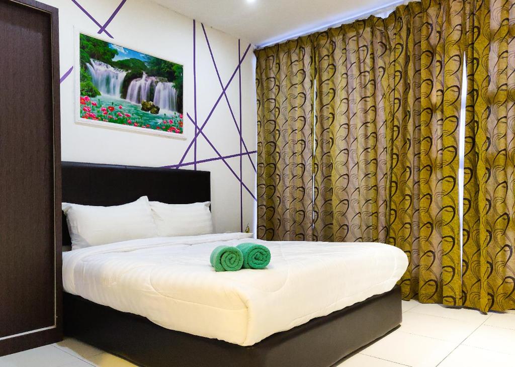 1 dormitorio con 1 cama y 2 toallas verdes en Hotel Double Star Klia, en Sepang