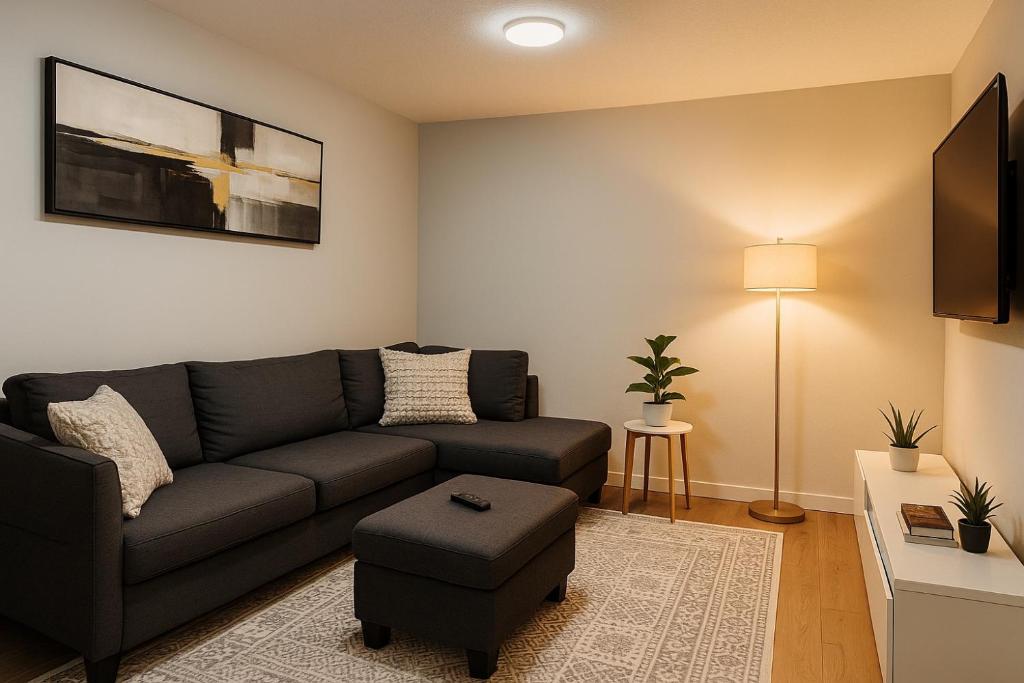 una sala de estar con un sofá y una mesa en The Seton Nook - 1BR Suite Near Seton Health Campus, Cineplex and YMCA, en Calgary