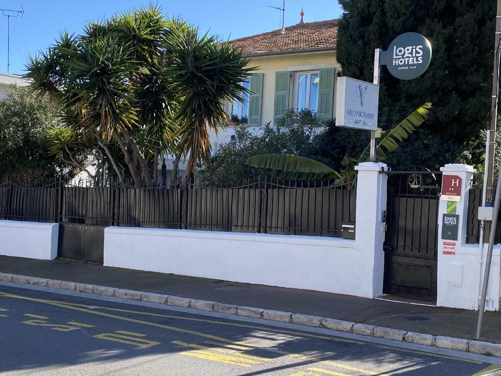 a white fence in front of a house at Logis Hôtel Villa Victorine in Nice