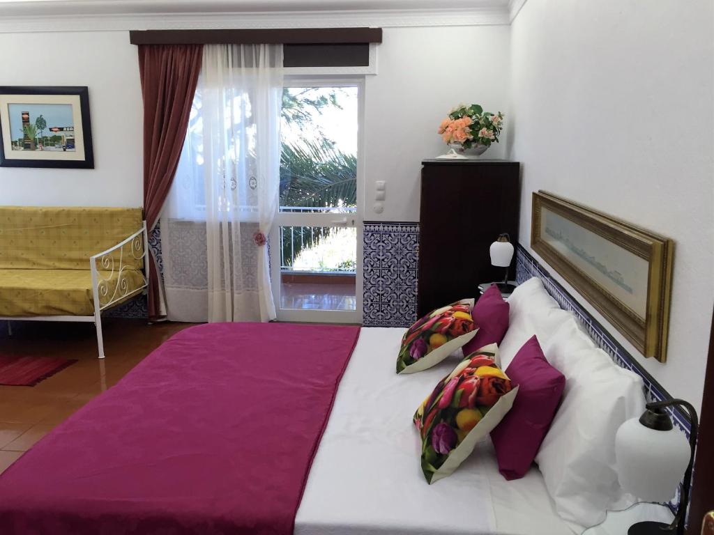 a bedroom with a large bed with purple pillows at Cascais Jasmim Doce in Cascais