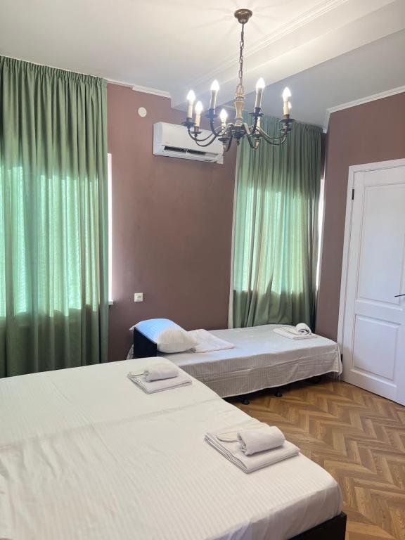 a bedroom with two beds and a chandelier at Hotel maisis ezo in Kutaisi