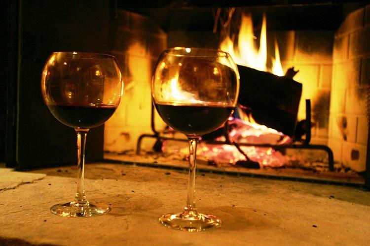 two glasses of wine sitting in front of a fireplace at Suite Paradiso Umbria 15 minutes A1 Rome 1 hour in Amelia