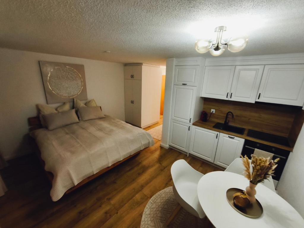 ein Schlafzimmer mit Bett und Tisch und eine Küche in der Unterkunft Apartment Panorama in Eischoll