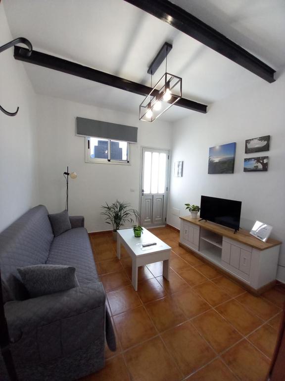 een woonkamer met een bank en een tv bij Casa Tomás - Zona Rural in Fasnia