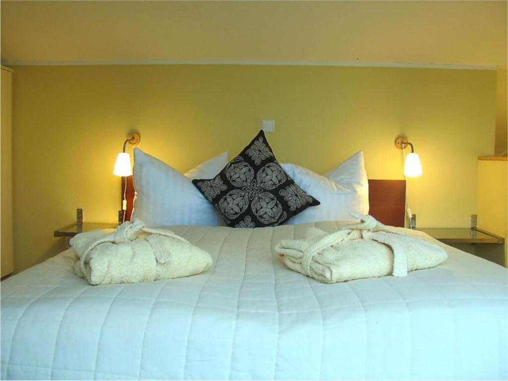 a large white bed with two towels on it at elegant eingerichtete Ferienwohnung in Granzow