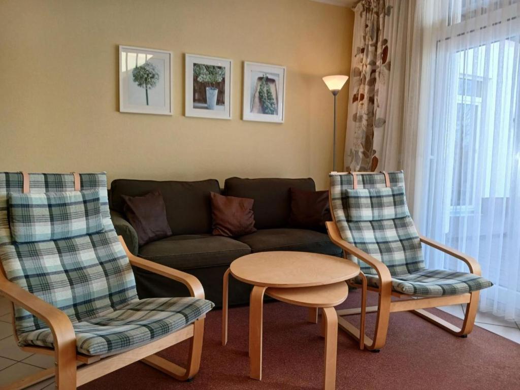 a living room with a couch and two chairs and a table at elegant eingerichtete Ferienwohnung in Granzow
