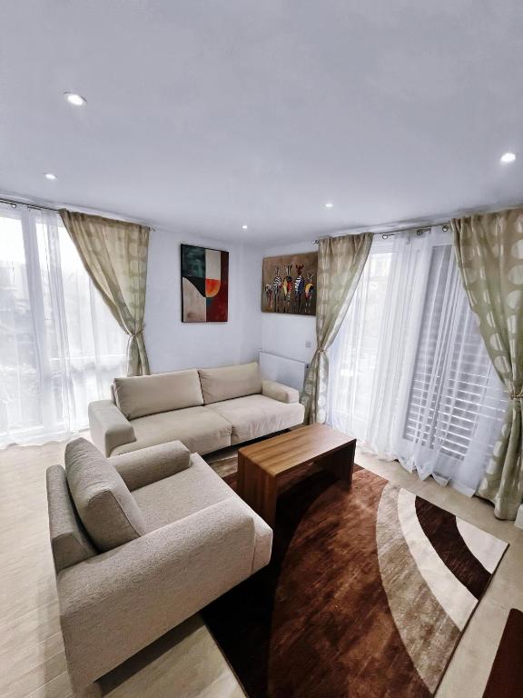 a living room with two couches and a table at Luxury 2-Bedroom London Apartment, 25mins to Liverpool Street, Balcony, Free Parking in London