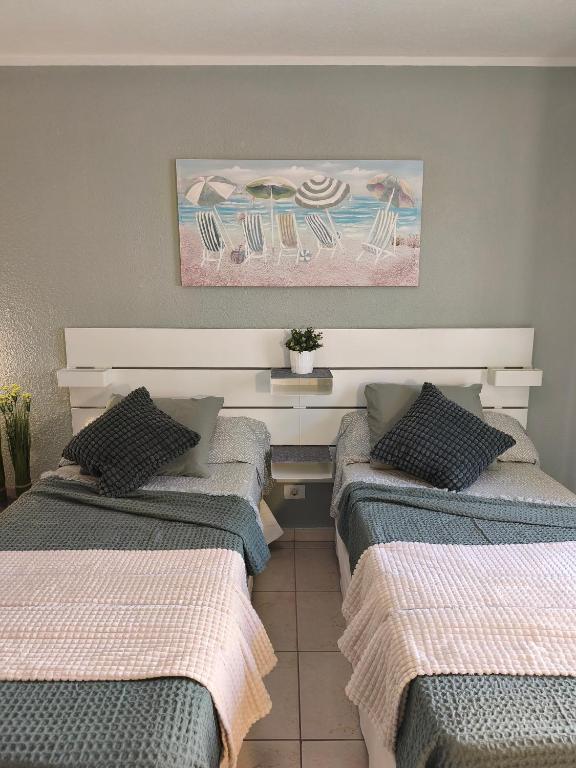 a room with three beds with chairs and a painting at Dreams Castle in Los Cristianos