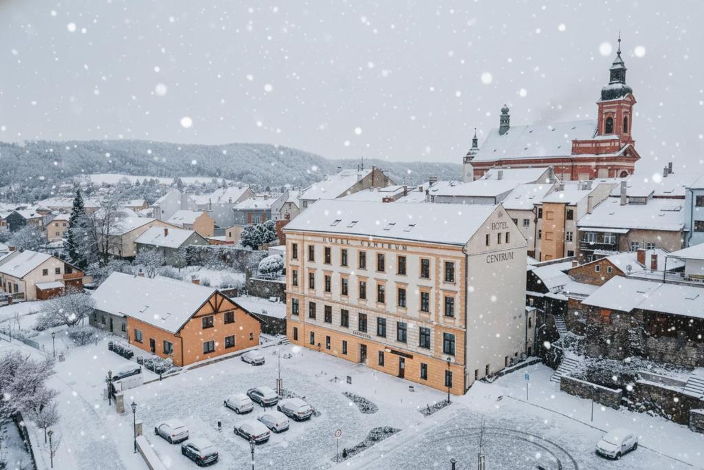 a city in the snow with cars parked at Hotel Centrum in Hranice