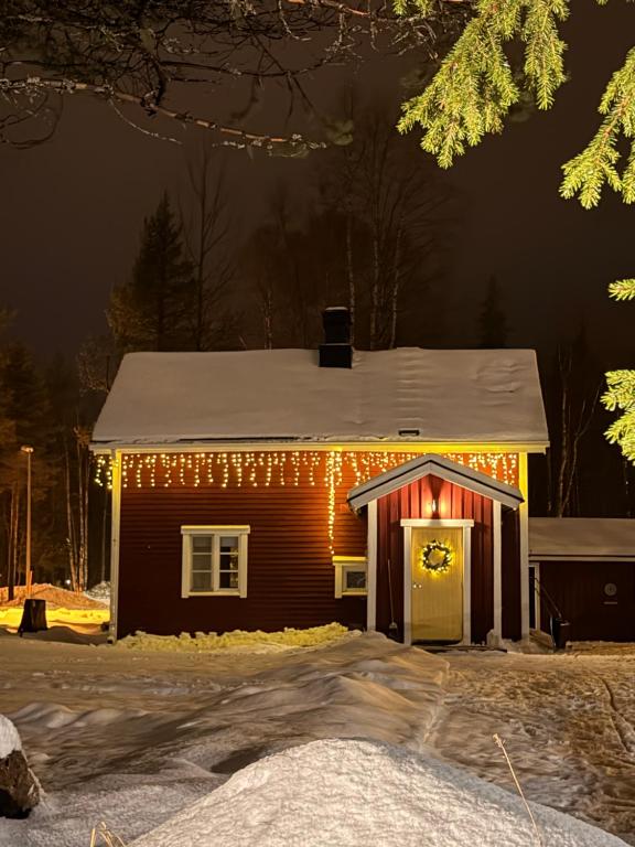 a house with christmas lights on it at night at Perinteinen mökki, walking distance from centre in Kittilä