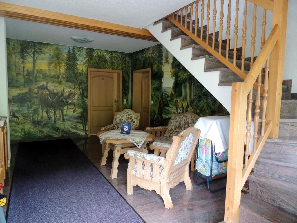 ein Zimmer mit einer Treppe und einem Gemälde an der Wand in der Unterkunft Gästehaus Am Hirtenberg in Breitenbrunn