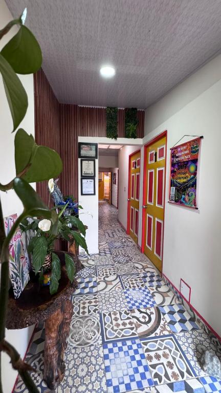 a hallway with a tile floor and a plant in a room at Apartahotel Bareque centro in Salento