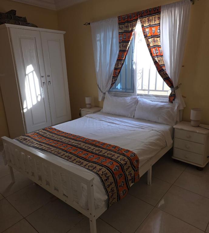 Schlafzimmer mit einem Bett und einem Fenster in der Unterkunft Mount Pleasant in Brufut
