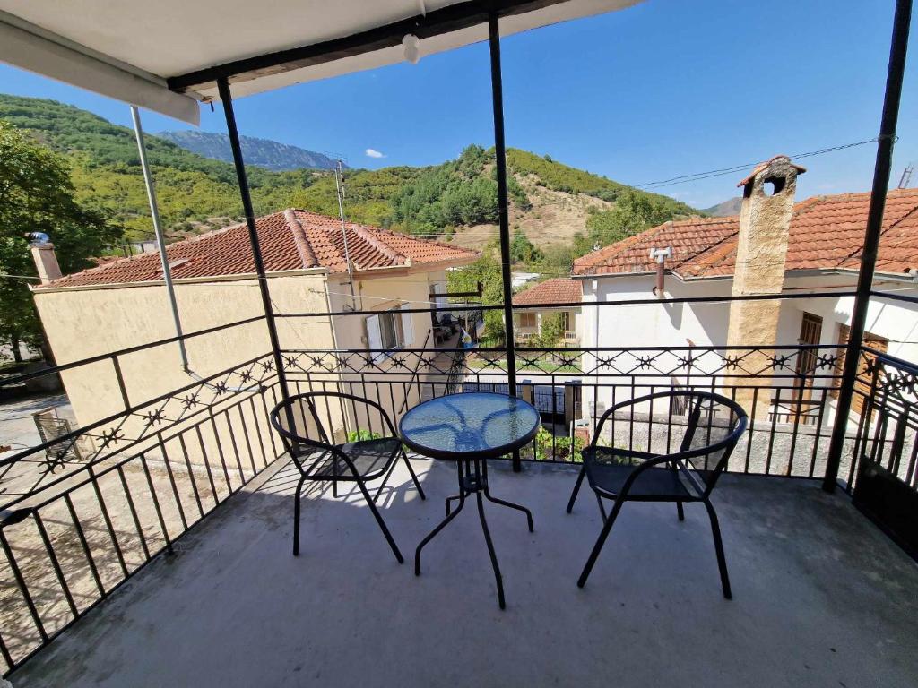 a patio with two chairs and a table on a balcony at Σπίτι στο χωριό in Filýra