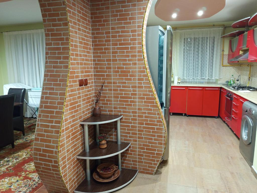 a kitchen with a brick wall with a fireplace at Harta in cui in Sighetu Marmaţiei