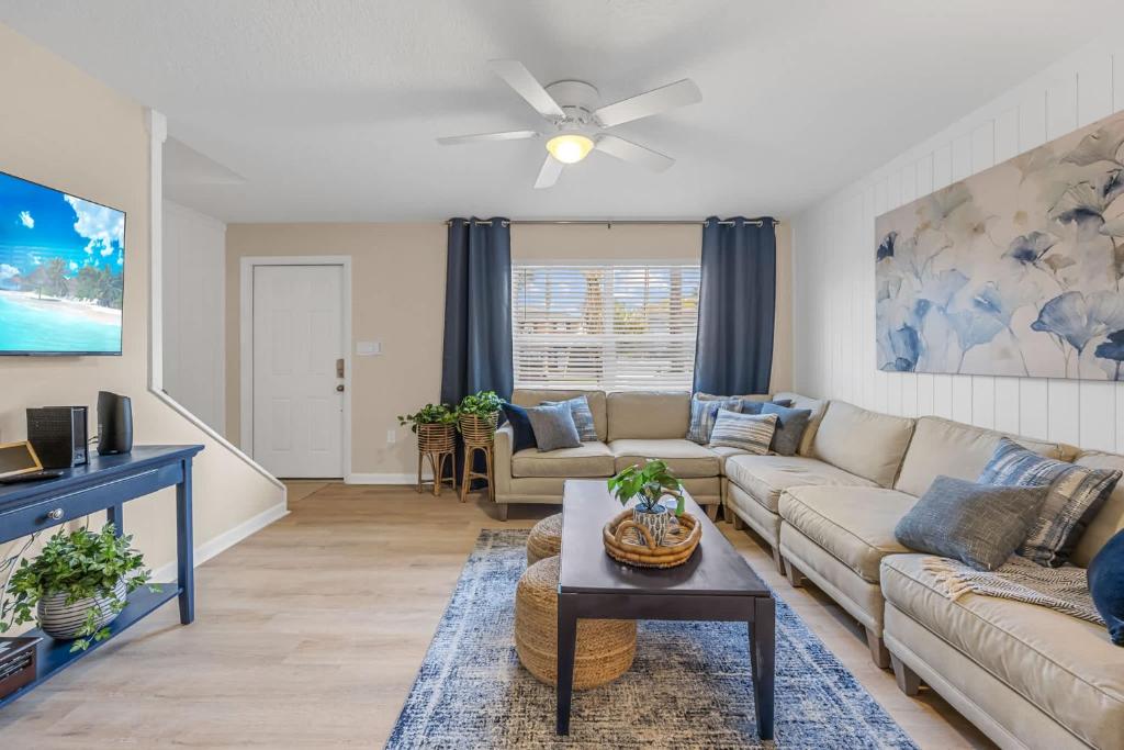 a living room with a couch and a table at Launch and Lounge Cozy Cape Canaveral Beach Townhome Near Surf and Space in Cape Canaveral