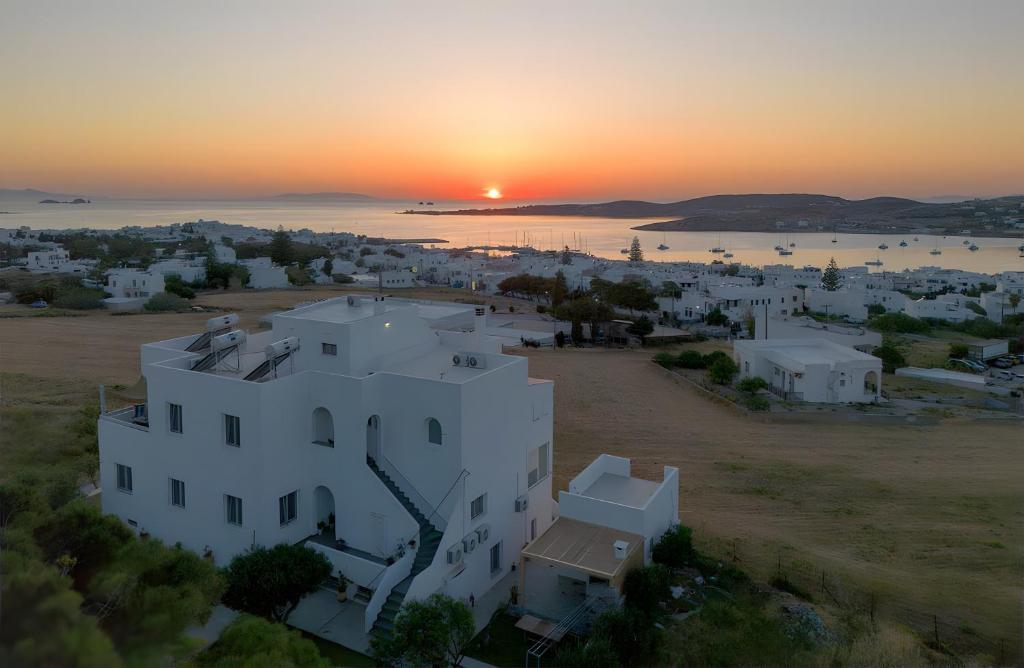 an aerial view of a white building with the sunset in the background at Crystal Dream Paros in Ekatondapilianí