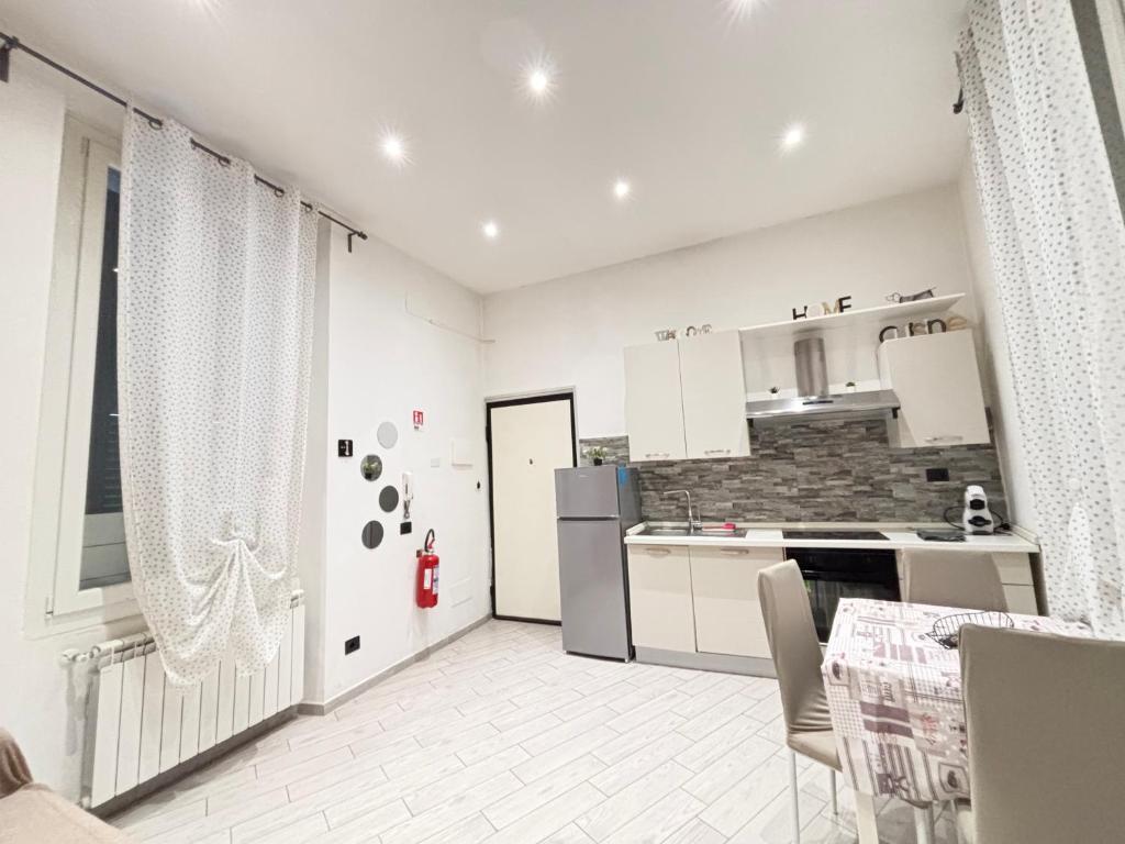 a kitchen with white cabinets and a table and chairs at Il filo di Claudia in Savona