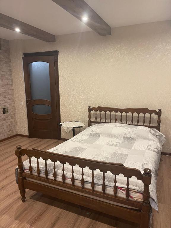 a bedroom with a bed with a wooden frame at Будинок у Олени in Pochayiv