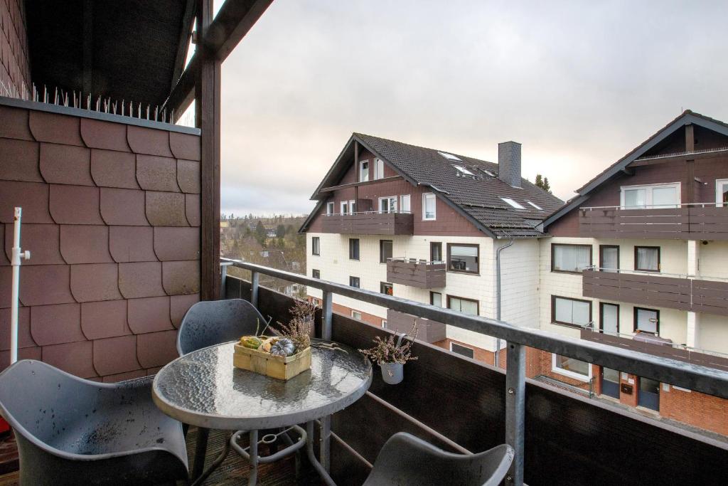ein Balkon mit Tisch und Stühlen und ein Gebäude in der Unterkunft Harzlicht Braunlage in Braunlage